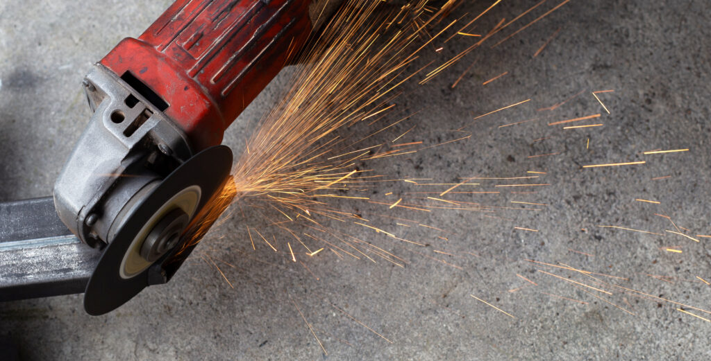 Close up angle grinder. Iron gate repair